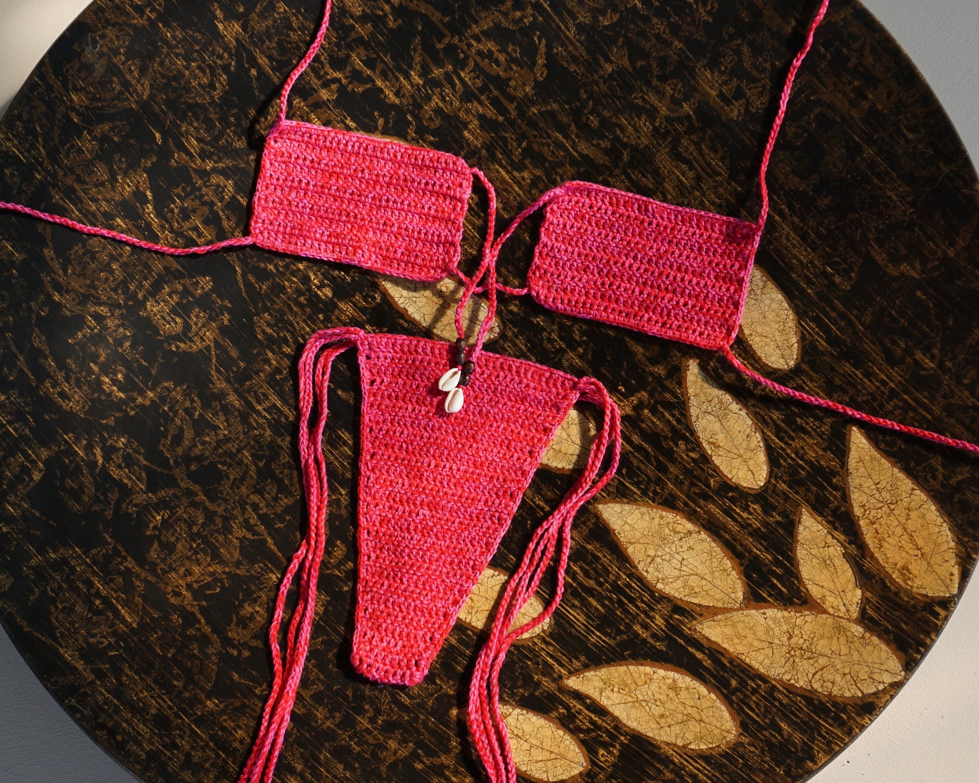 pink tie front brazilian crochet bikini set with shells for swimming flatlay